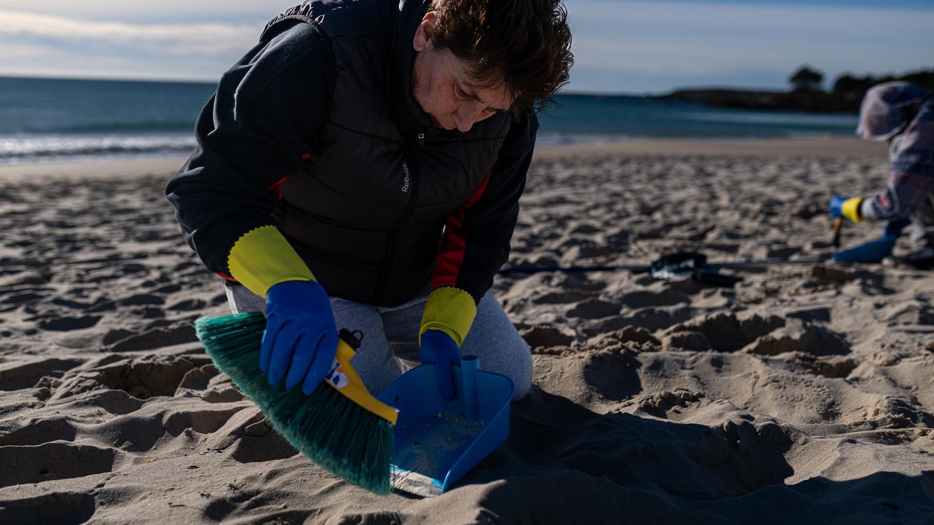 Voluntarios siguen recogiendo las bolitas plásticas en la costa gallega entre el rifirrafe de los políticos
