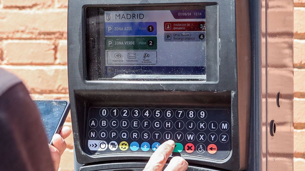 Une personne utilise un parcomètre à Madrid.