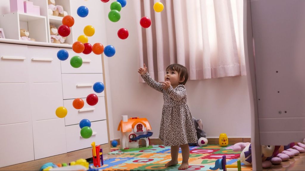 Une fille jetant des boules colorées en l’air