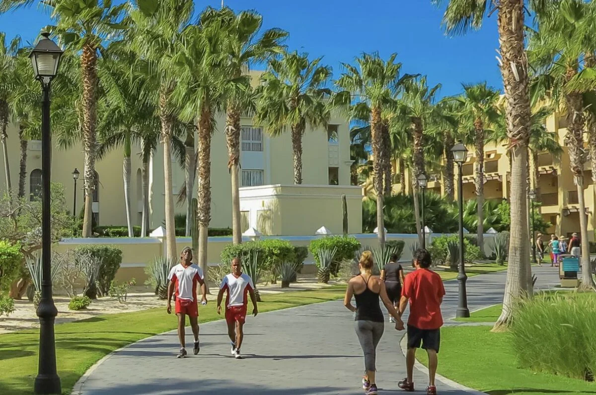 Des touristes américains passent devant le personnel d'un complexe hôtelier à Cabo San Lucas
