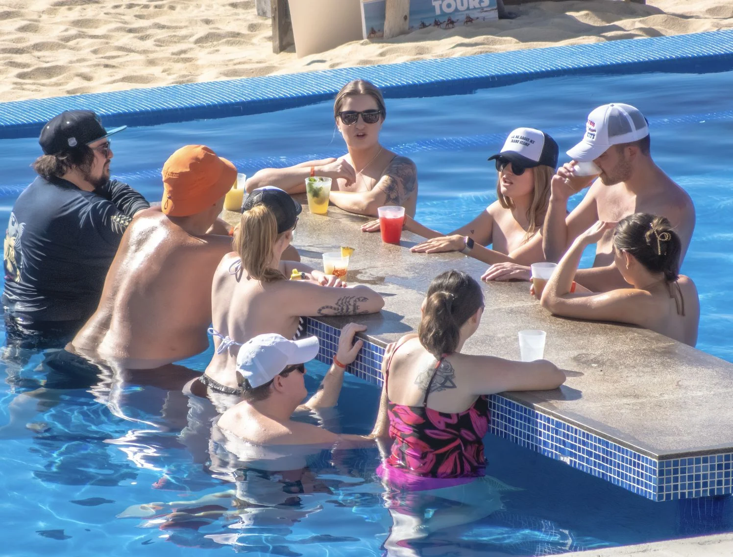 Les voyageurs américains profitent d'un bar dans la piscine d'un complexe à Los Cabos, au Mexique