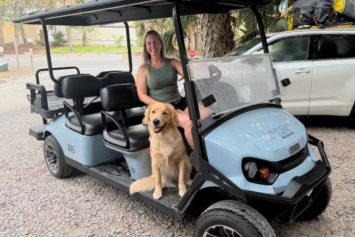 Liz Fox avec un golden retriever sur une voiturette de golf à Fripp Island, Caroline du Sud