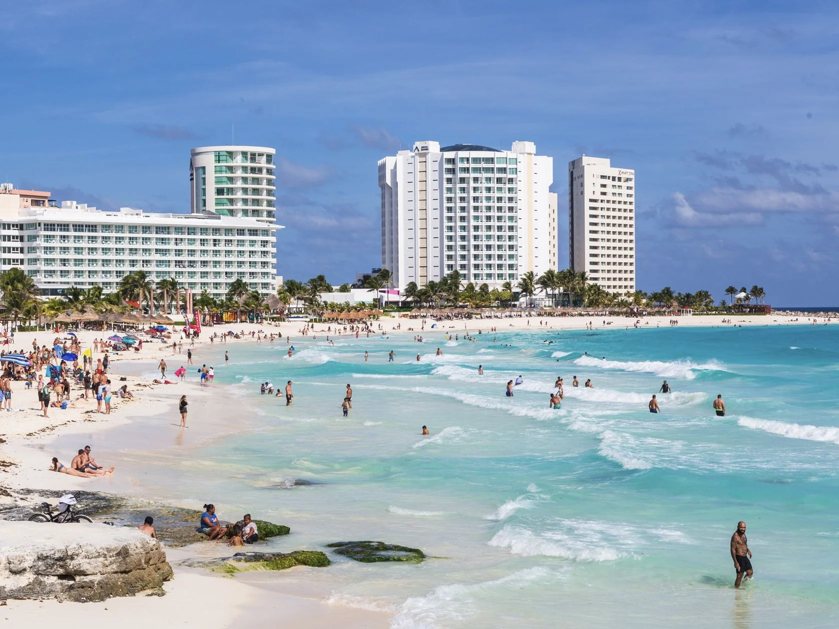 Plage de la zone hôtelière avec des touristes américains dans l'eau bleue turquoise de Cancun