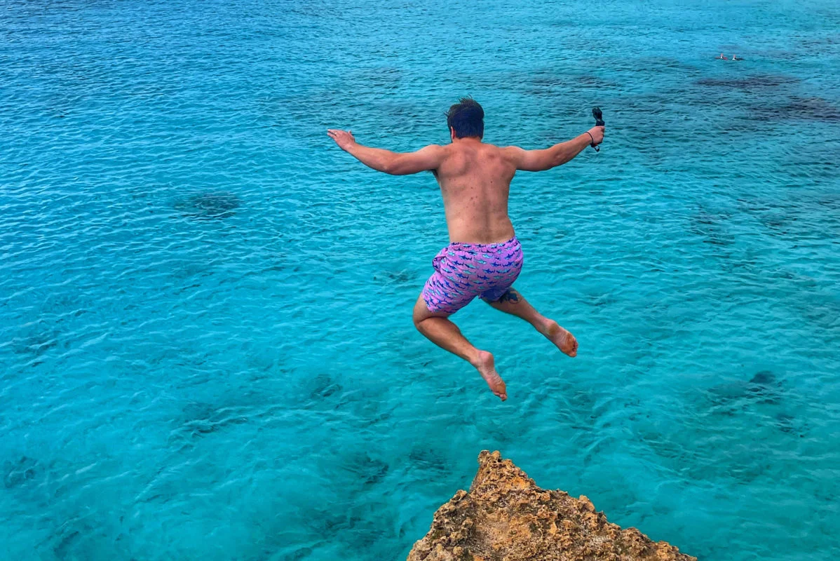 Tyler Fox sautant d'une falaise à Boca Slagbaai à Bonaire