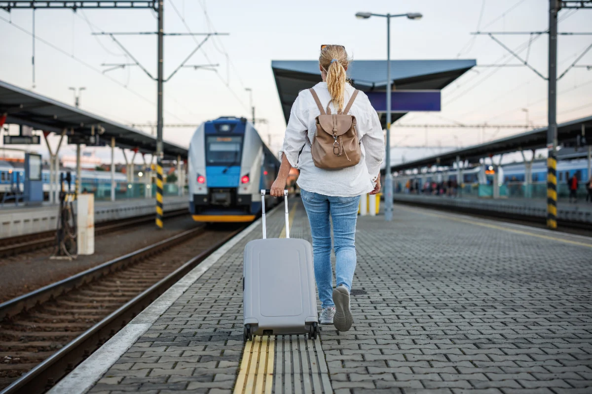 Femme avec bagages à la gare