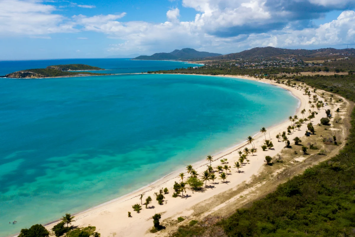Belle plage de Sun Bay avec de petits bateaux de pêche et des gens se détendant, située sur l'île tropicale des Caraïbes de Vieques, Porto Rico