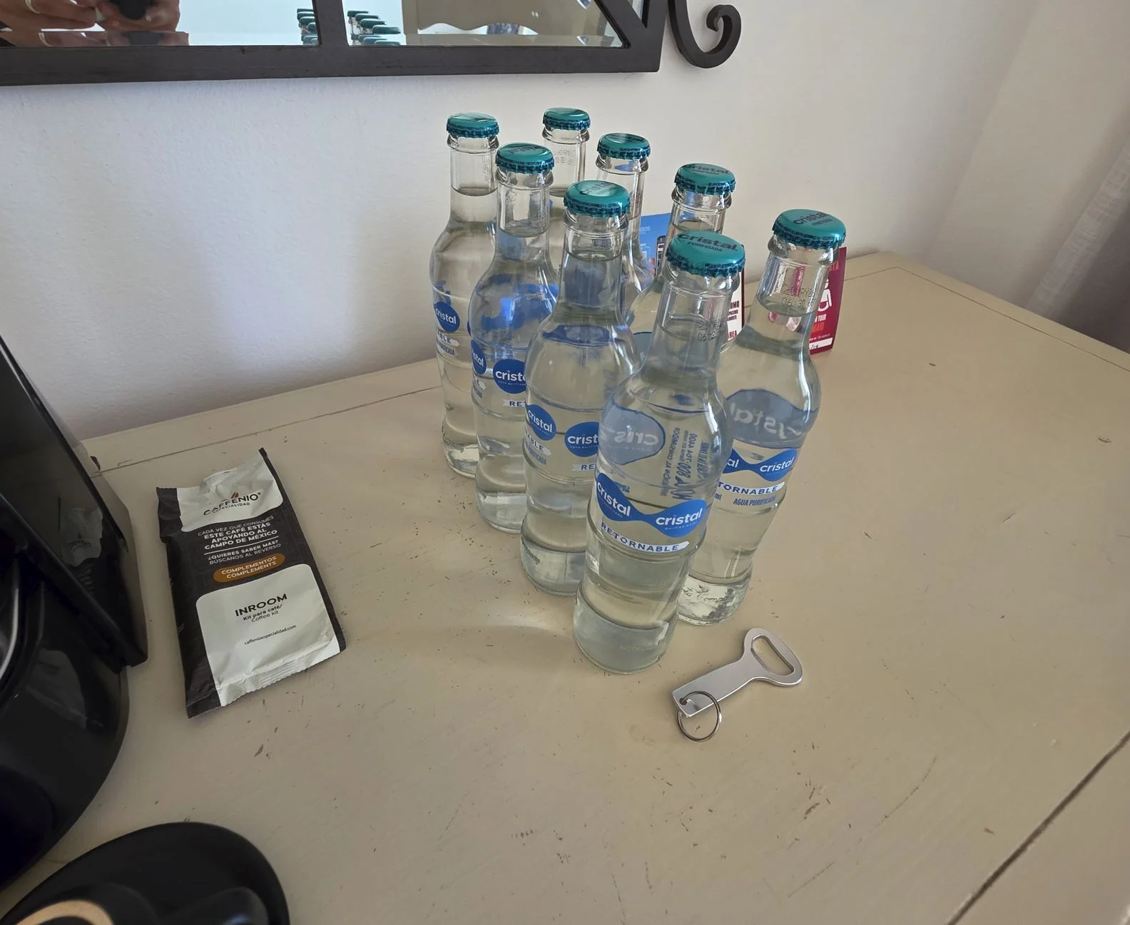 Bouteilles-d'eau-extra-dans-la-chambre-d'hôtel-au-Sandos-Cancun-Resort-Ouvre-bouteille-sur-table.-Photo-originale-par-Trevor-Kucheran
