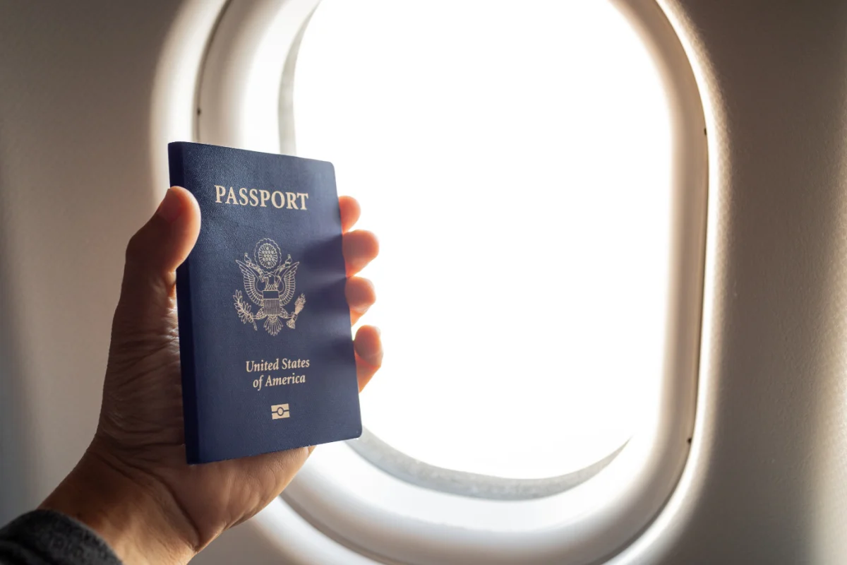 Passager titulaire d'un passeport américain dans un avion avec la fenêtre en arrière-plan