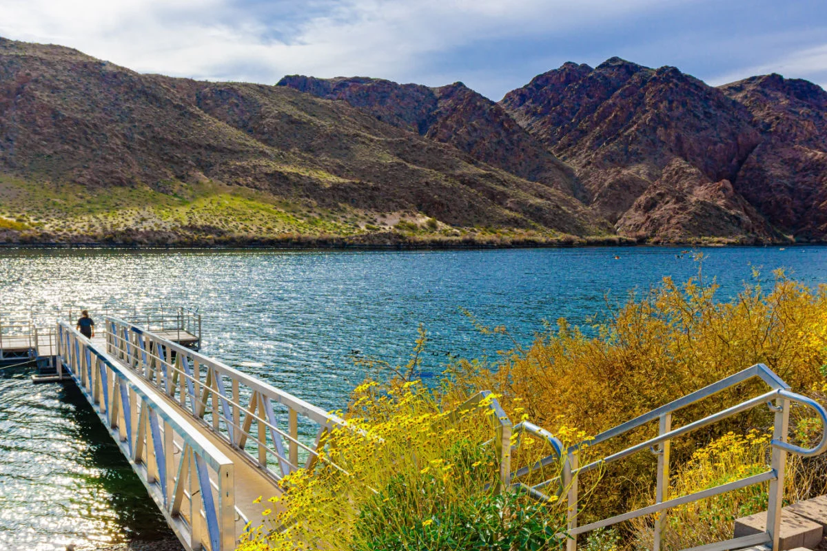 Touriste féminin marchant sur la jetée de pêche sur le fleuve Colorado à la marina de Willow Beach, zone de loisirs nationale de Lake Mead, Arizona, États-Unis