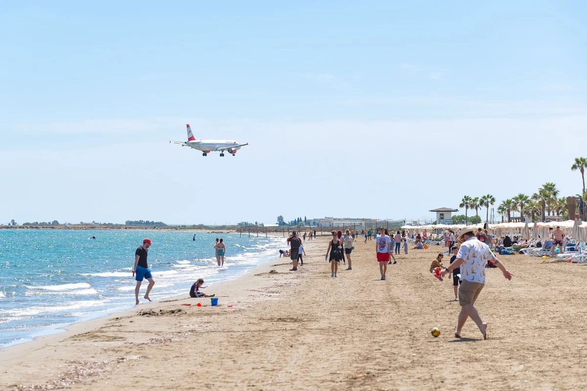 Plage de sable avec un avion survolant, Chypre