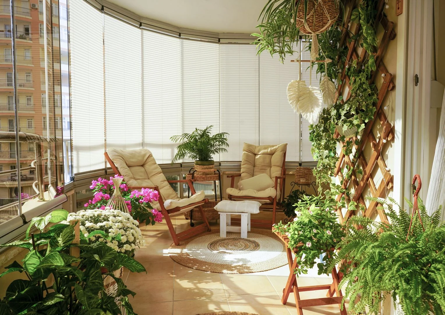 Balcon lumineux et confortable décoré de plantes en pot luxuriantes, d'accents en osier et de chaises pliantes
