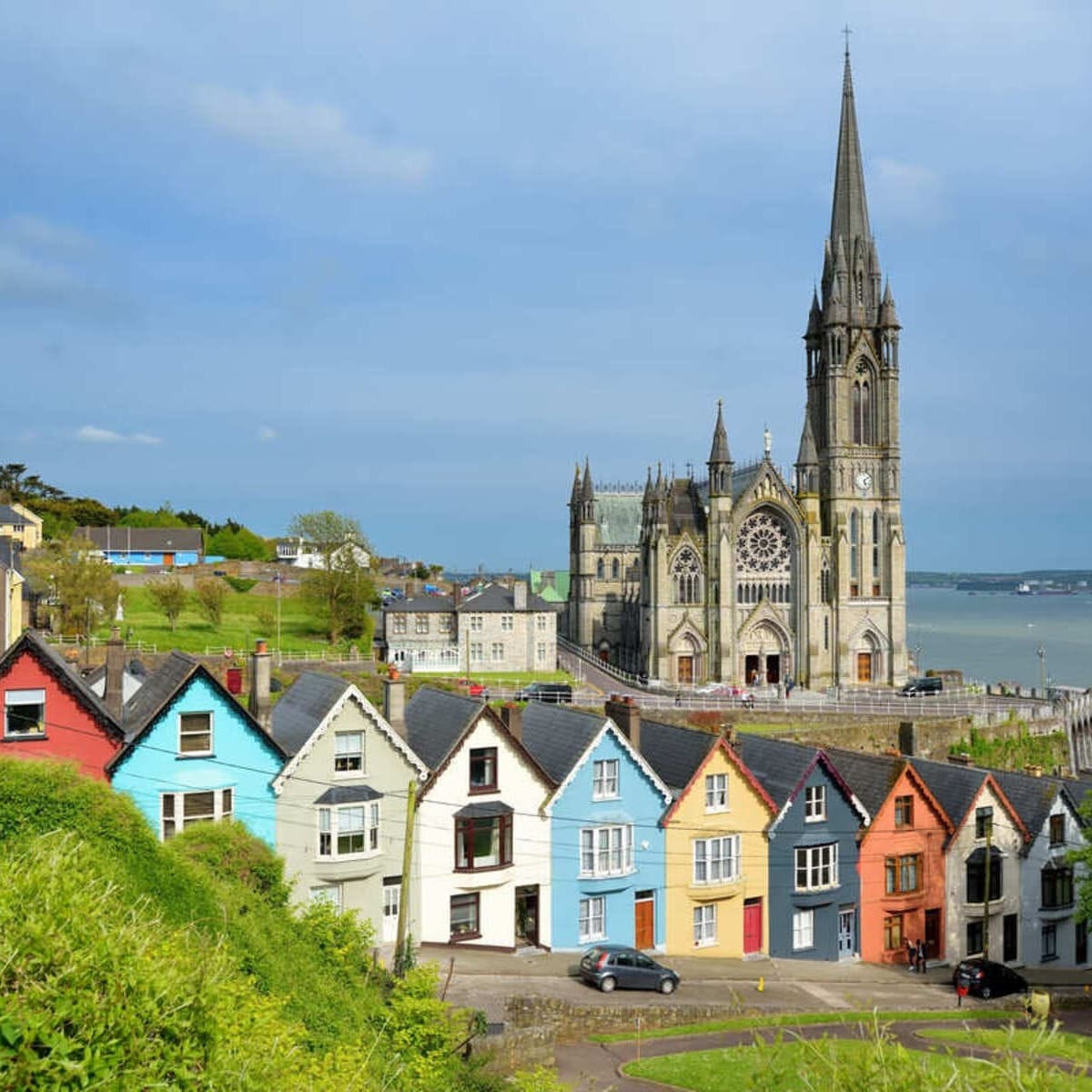 Rangée colorée de maisons avec une cathédrale en arrière-plan à Cobh près de Cork, Irlande