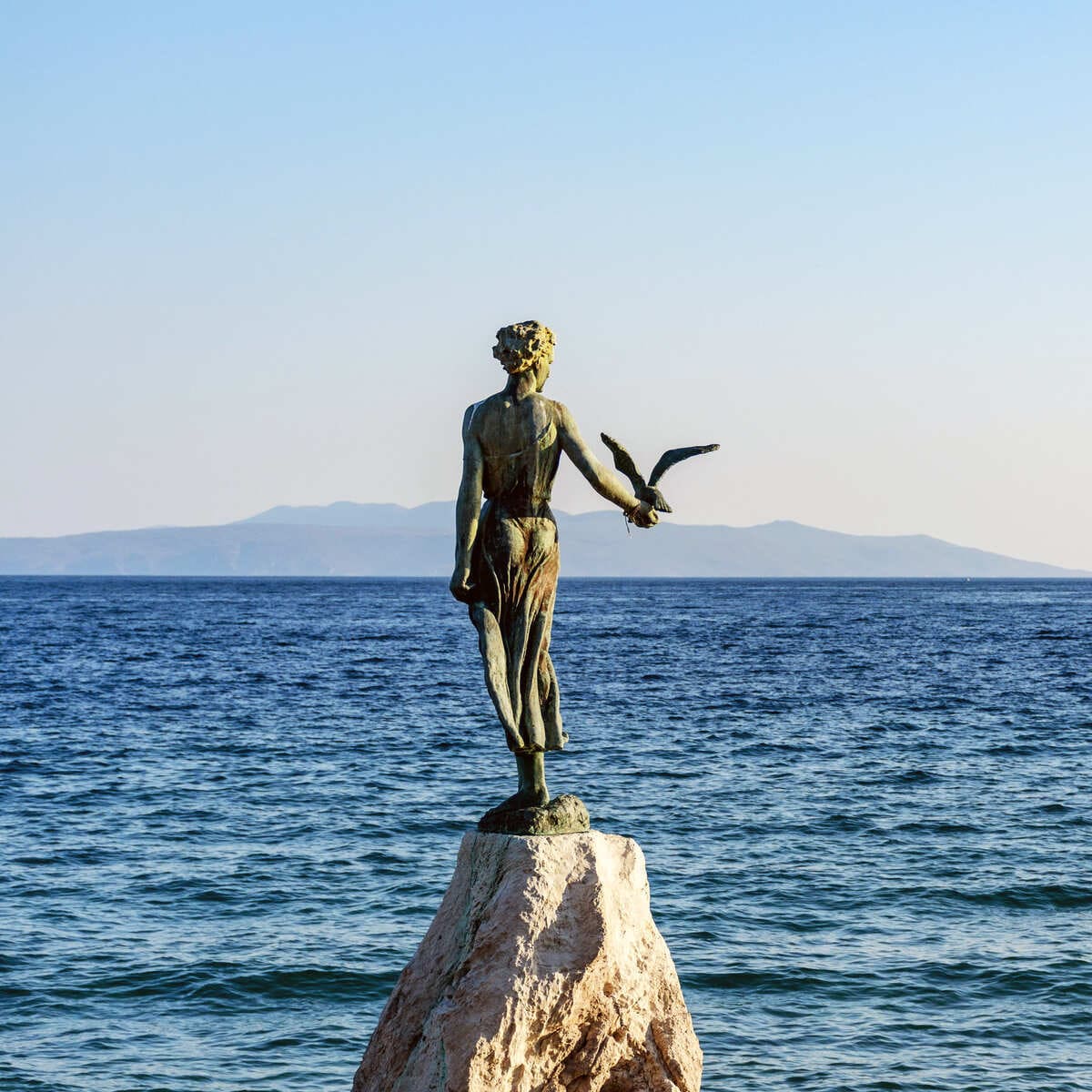 Jeune fille avec la sculpture de mouette à Opatija, Croatie