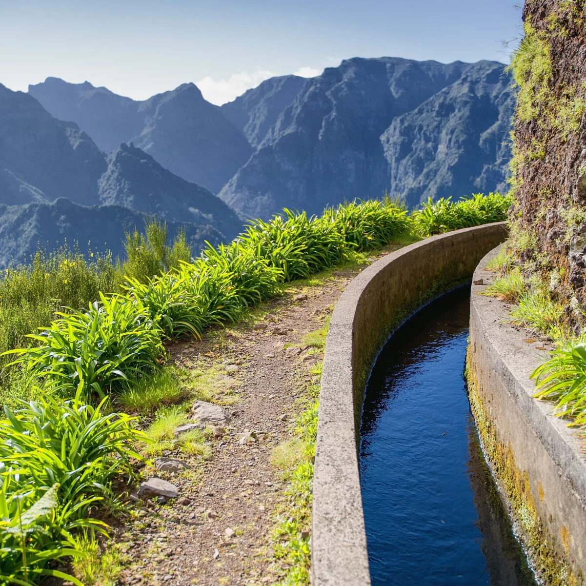Vue depuis Levada do Norte sur l'île portugaise de Madère. Printemps à Madère. Canal d'irrigation de la Levada. Randonnée à Madère. Sentier étroit à côté de la levada. Montagnes vertes en arrière-plan.