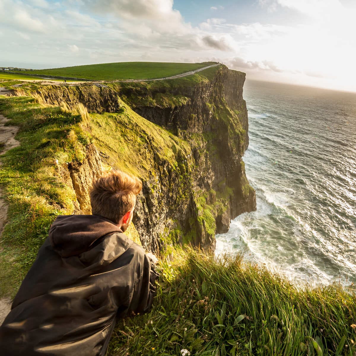 Jeune homme admirant une vue sur les falaises de Moher, Irlande