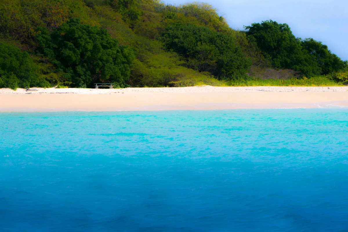 Eaux bleues vibrantes le long d'une plage isolée à Sainte-Croix