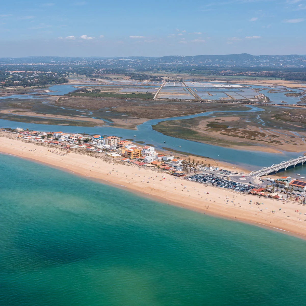 Praia de Faro le long de la côte de Ria Formosa, Algarve, Portugal, capturée d'en haut avec de l'eau claire et des contours de terre par une journée ensoleillée