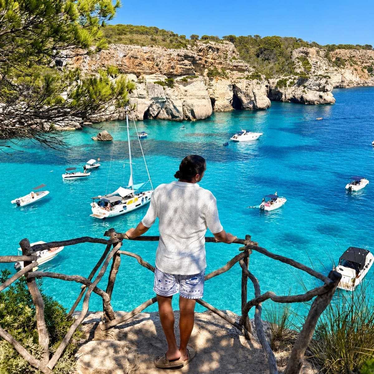 Touriste masculin admirant une vue sur la mer Méditerranée turquoise à Minorque, Îles Baléares, Espagne